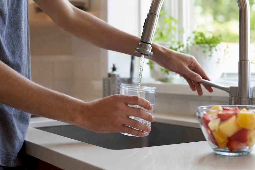 Hands collecting urine sample with cup