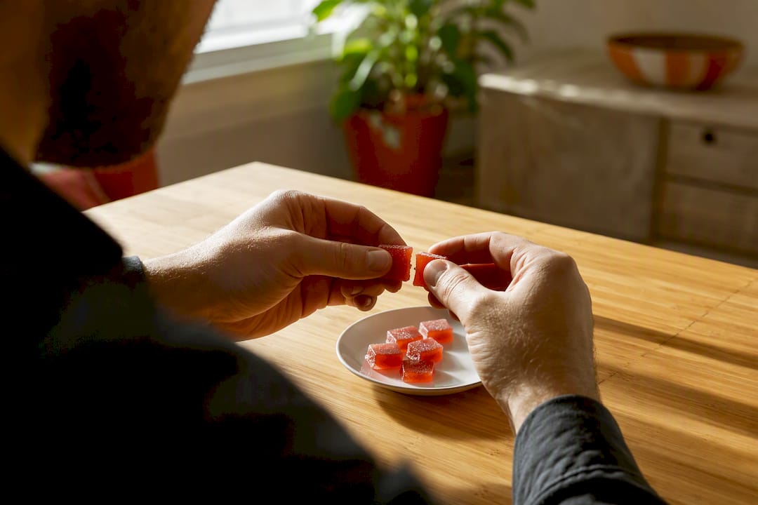 Hands breaking cannabis edible gummy