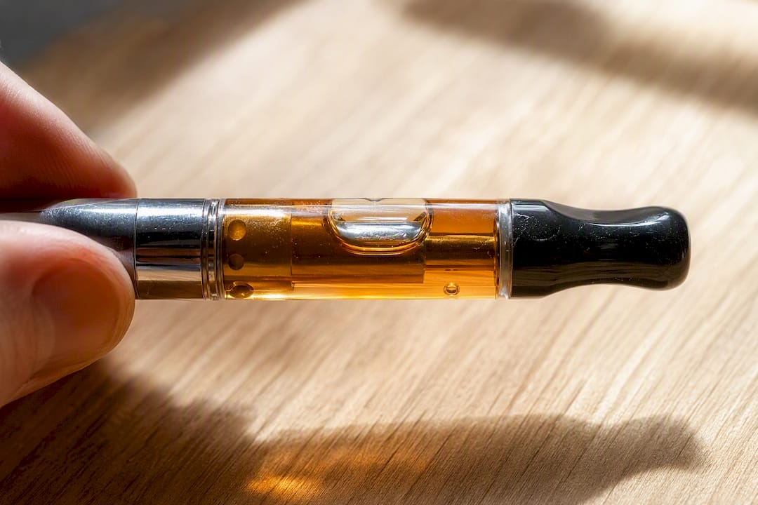 Close-up vape cartridge with amber liquid