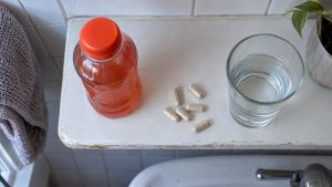 Detox drink bottle and capsules on shelf