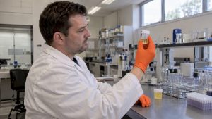 Analyst examining synthetic urine specimen vial