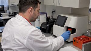 Technician loading urine sample for validity testing