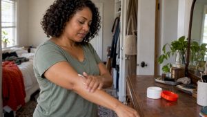 Woman applying topical cream to her forearm